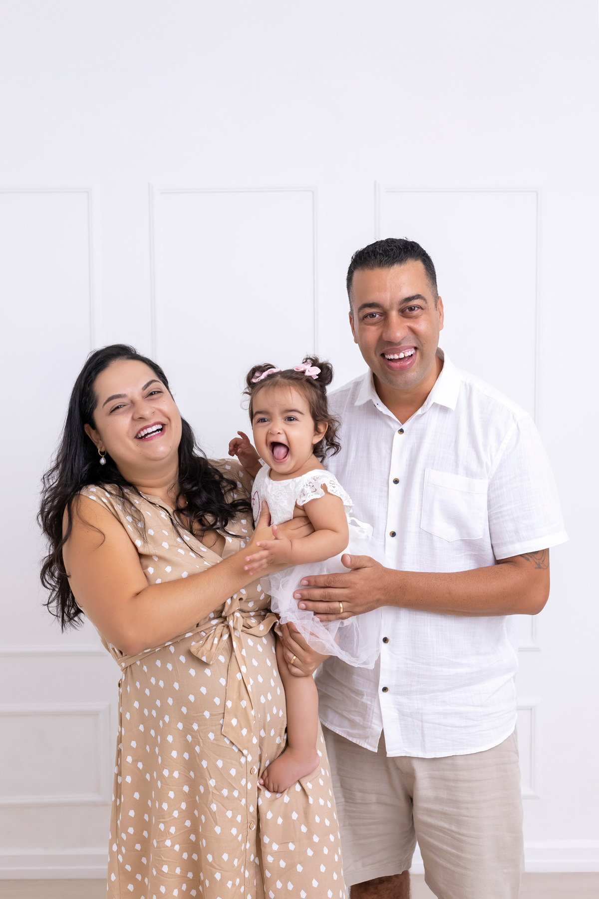 Bebê em ensaio Smash the Cake colorido com flores e raposinha em estúdio em Caraguatatuba, cenário personalizado em tons de rosa e laranja, criança sorrindo e brincando com o bolo de aniversário
