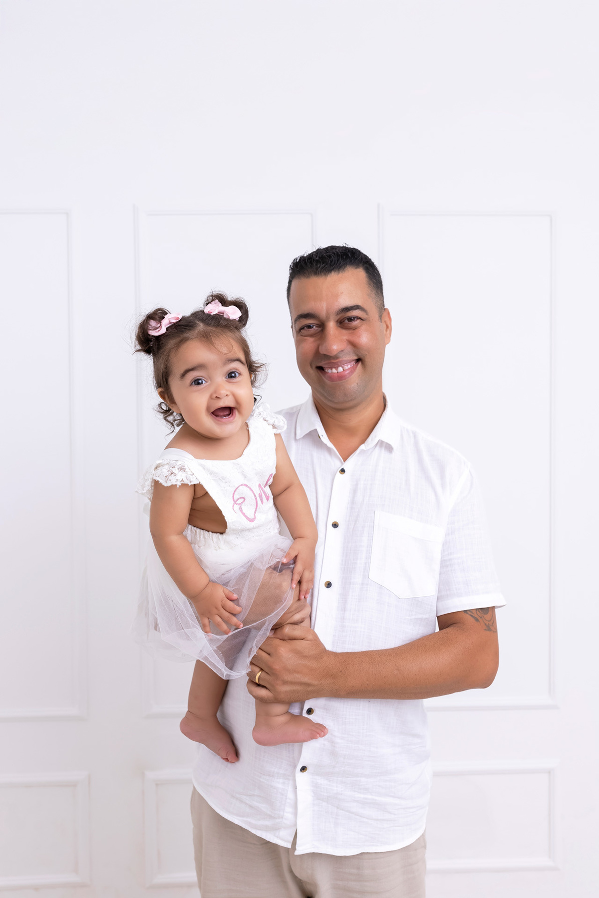 Bebê em ensaio Smash the Cake colorido com flores e raposinha em estúdio em Caraguatatuba, cenário personalizado em tons de rosa e laranja, criança sorrindo e brincando com o bolo de aniversário