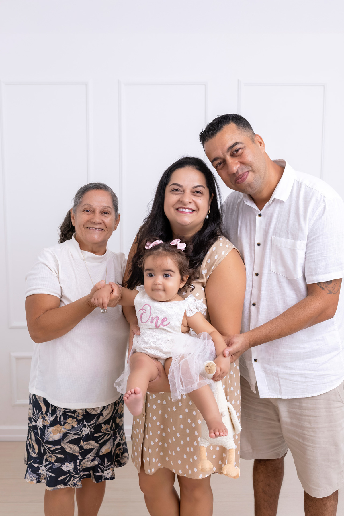 Bebê em ensaio Smash the Cake colorido com flores e raposinha em estúdio em Caraguatatuba, cenário personalizado em tons de rosa e laranja, criança sorrindo e brincando com o bolo de aniversário