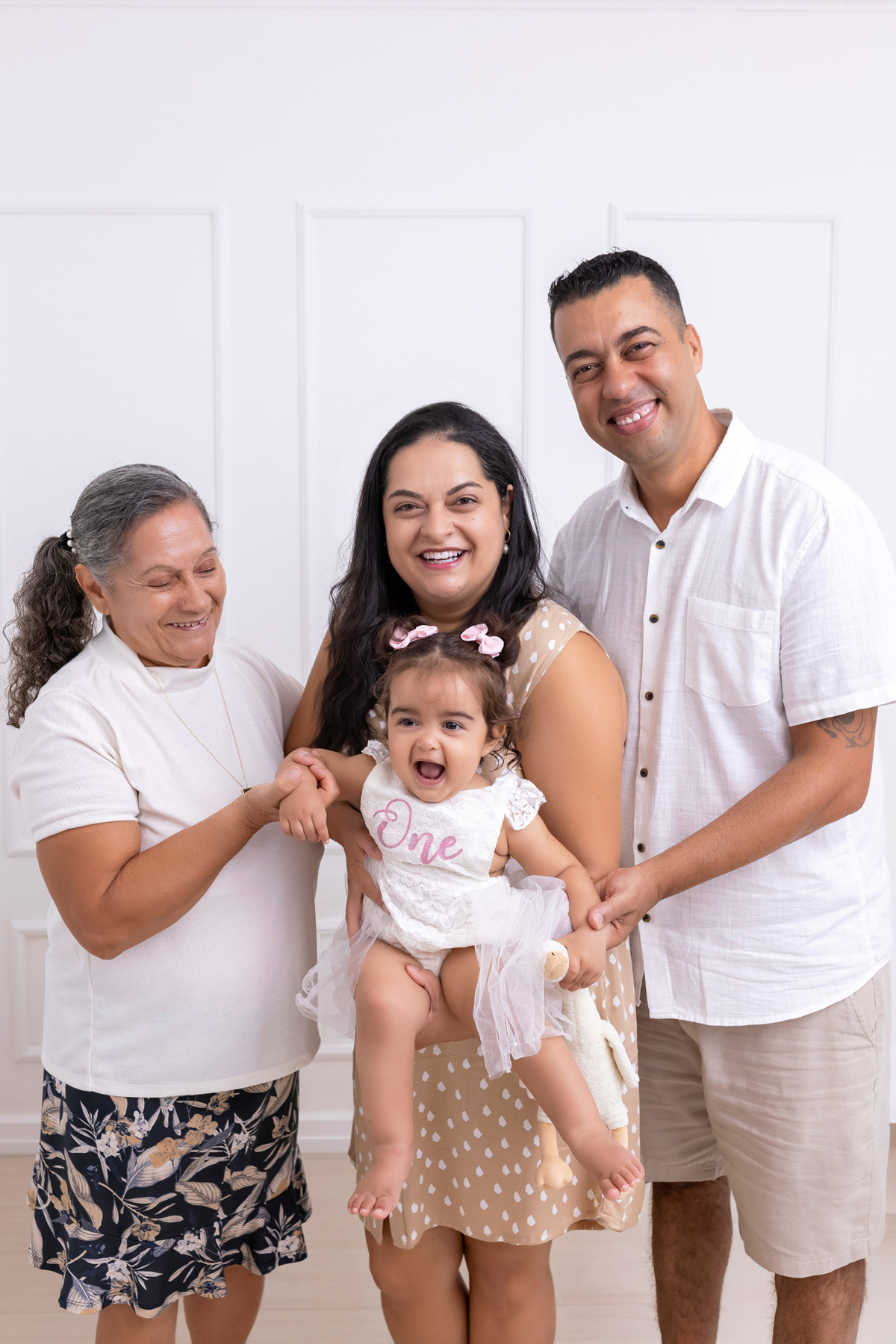 Bebê em ensaio Smash the Cake colorido com flores e raposinha em estúdio em Caraguatatuba, cenário personalizado em tons de rosa e laranja, criança sorrindo e brincando com o bolo de aniversário