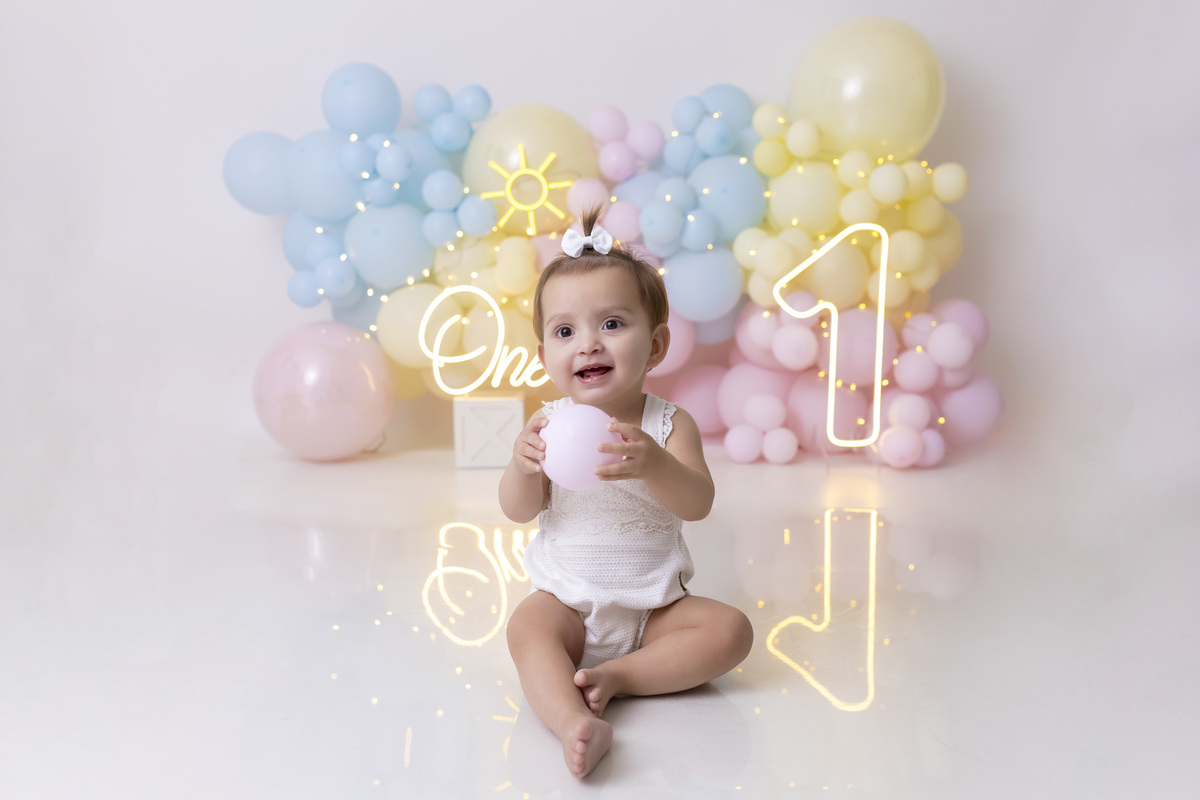 Bebê em ensaio Smash the Fruit tema sol com frutas frescas, cenário colorido e alegre, fotos de 1 ano em estúdio fotográfico em Caraguatatuba