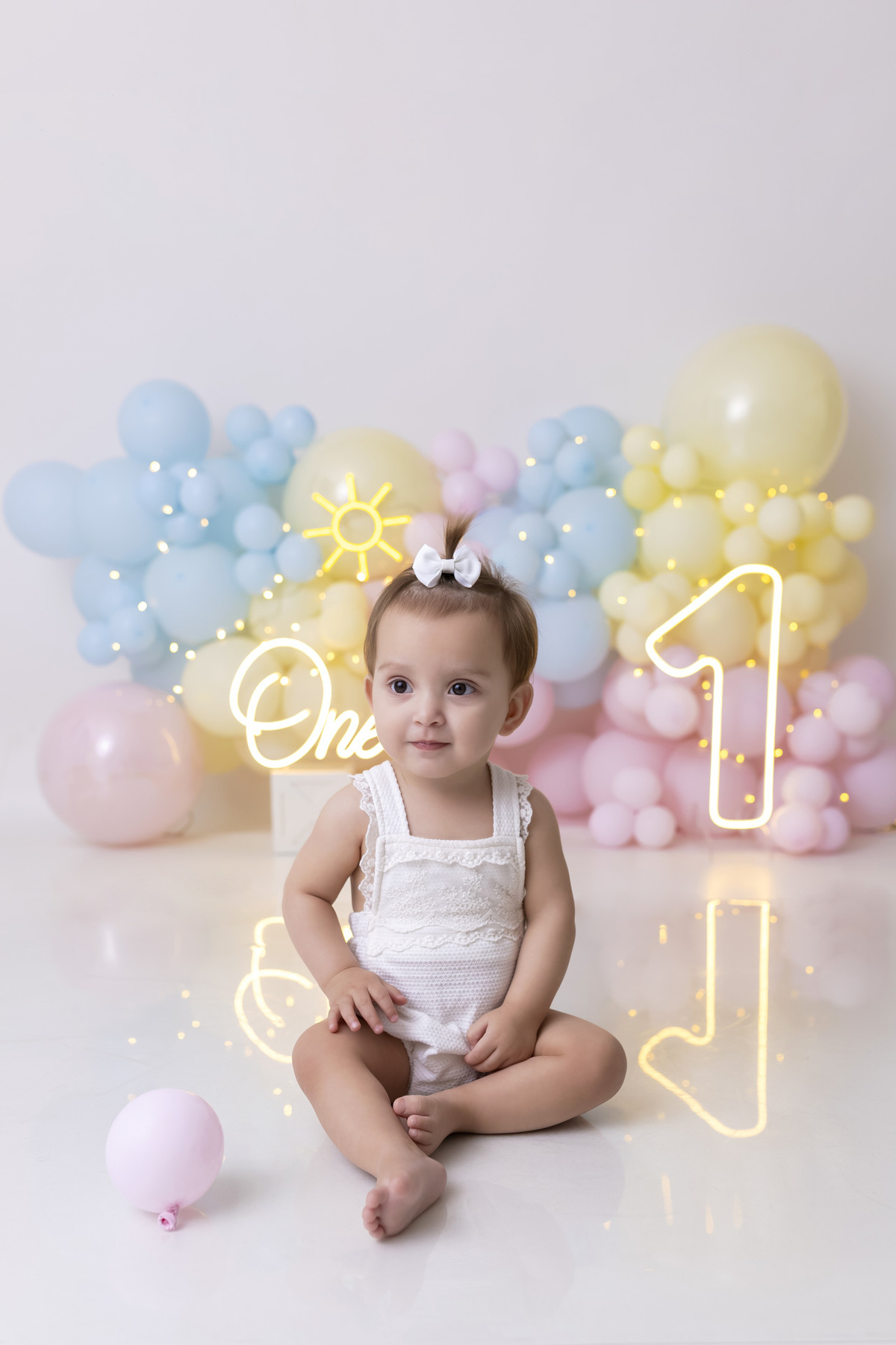 Bebê em ensaio Smash the Fruit tema sol com frutas frescas, cenário colorido e alegre, fotos de 1 ano em estúdio fotográfico em Caraguatatuba