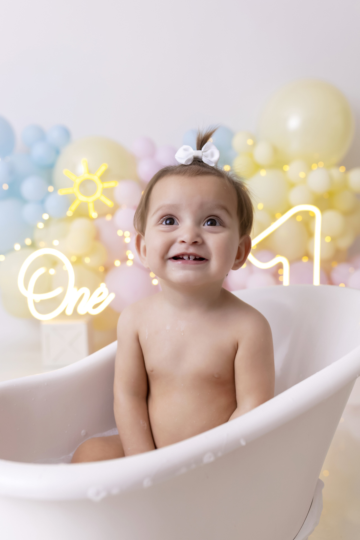 Bebê em ensaio Smash the Fruit tema sol com frutas frescas, cenário colorido e alegre, fotos de 1 ano em estúdio fotográfico em Caraguatatuba