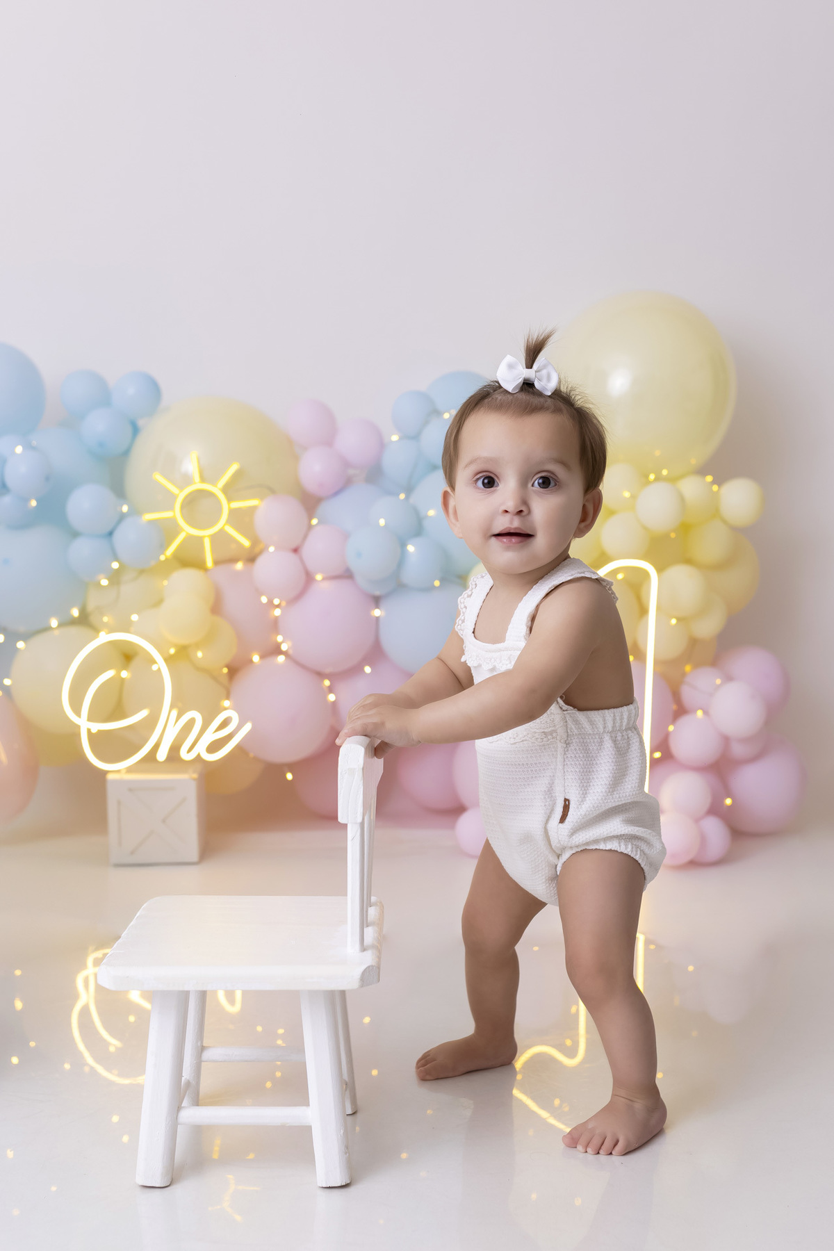 Bebê em ensaio Smash the Fruit tema sol com frutas frescas, cenário colorido e alegre, fotos de 1 ano em estúdio fotográfico em Caraguatatuba