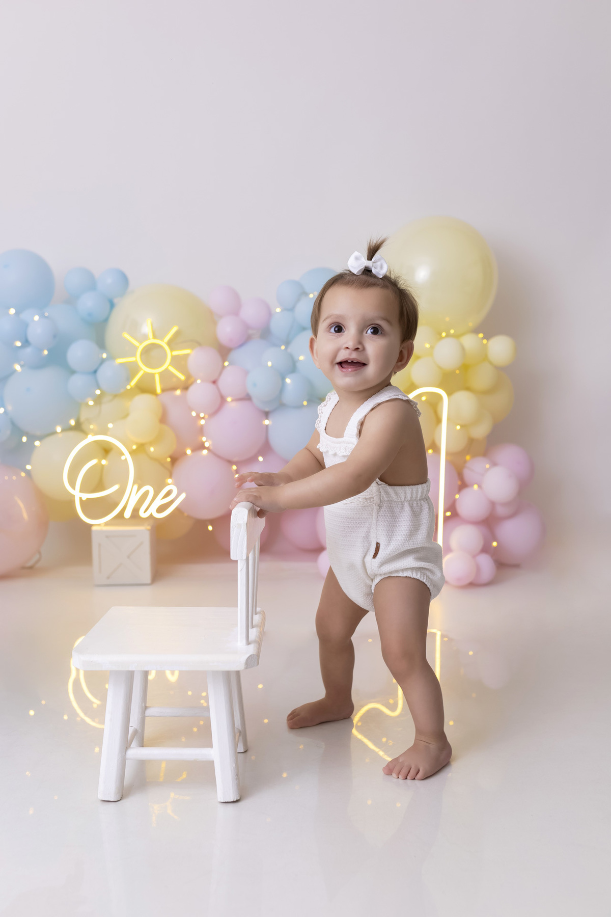 Bebê em ensaio Smash the Fruit tema sol com frutas frescas, cenário colorido e alegre, fotos de 1 ano em estúdio fotográfico em Caraguatatuba