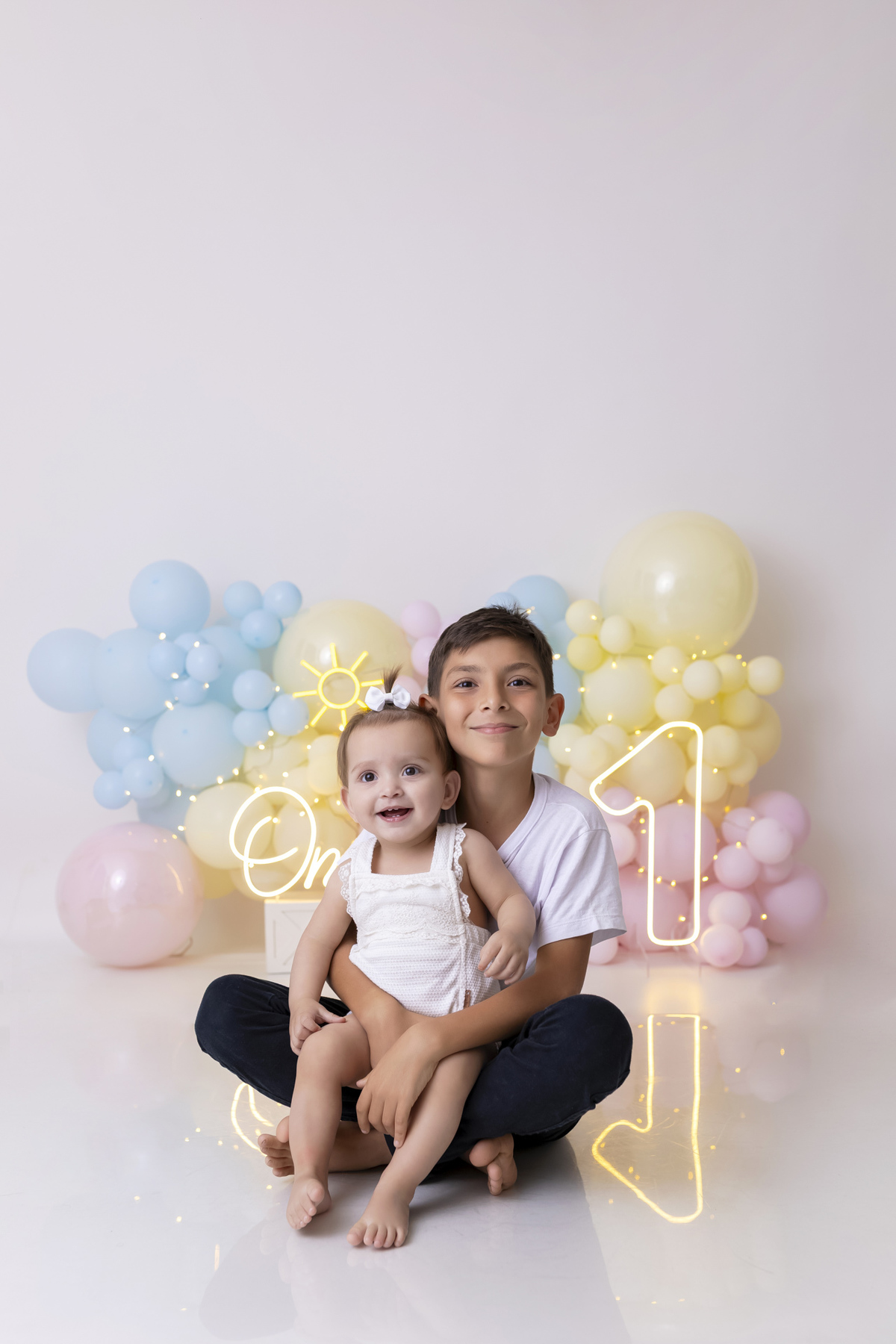 Bebê em ensaio Smash the Fruit tema sol com frutas frescas, cenário colorido e alegre, fotos de 1 ano em estúdio fotográfico em Caraguatatuba