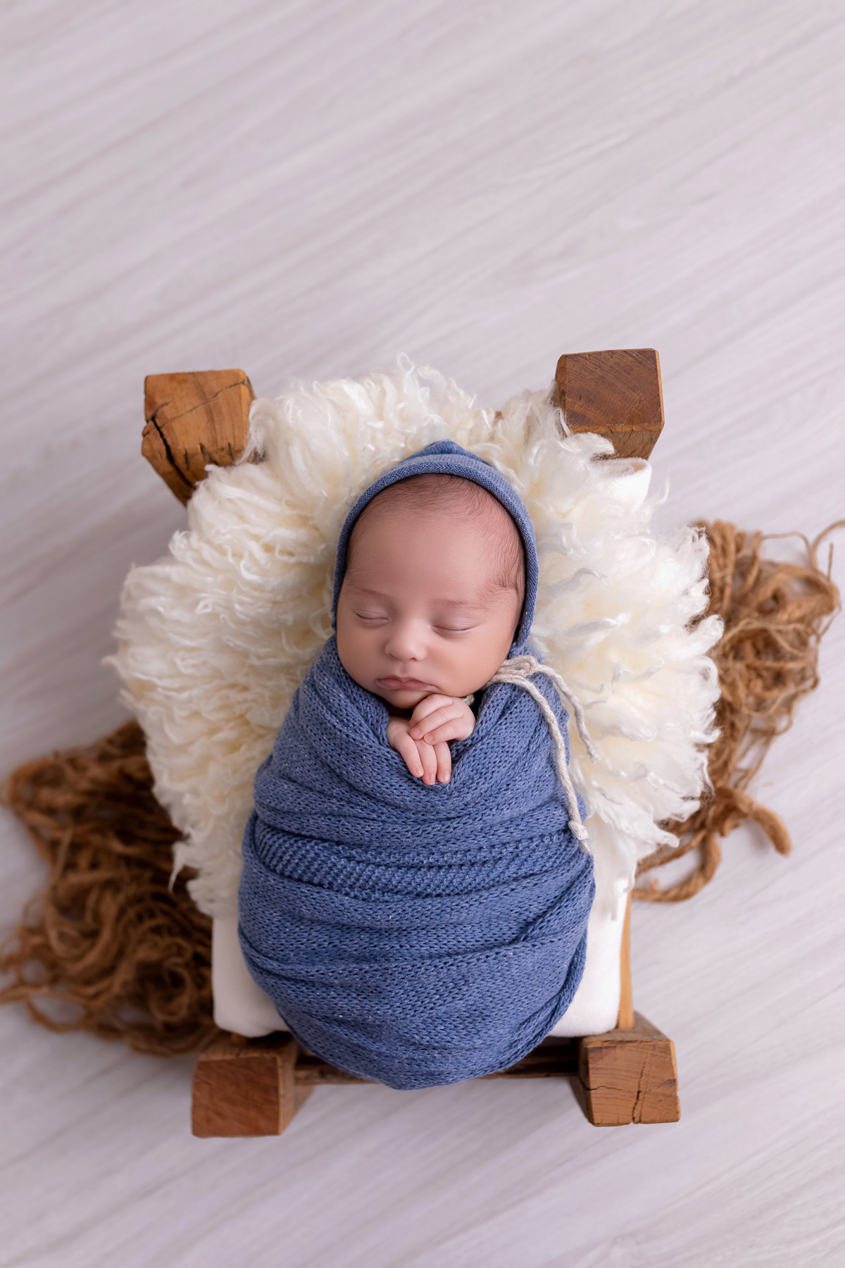 Bebê recém-nascido Levi enroladinho em tecido azul no baldinho durante ensaio newborn no estúdio On Click Fotografia em Caraguatatuba