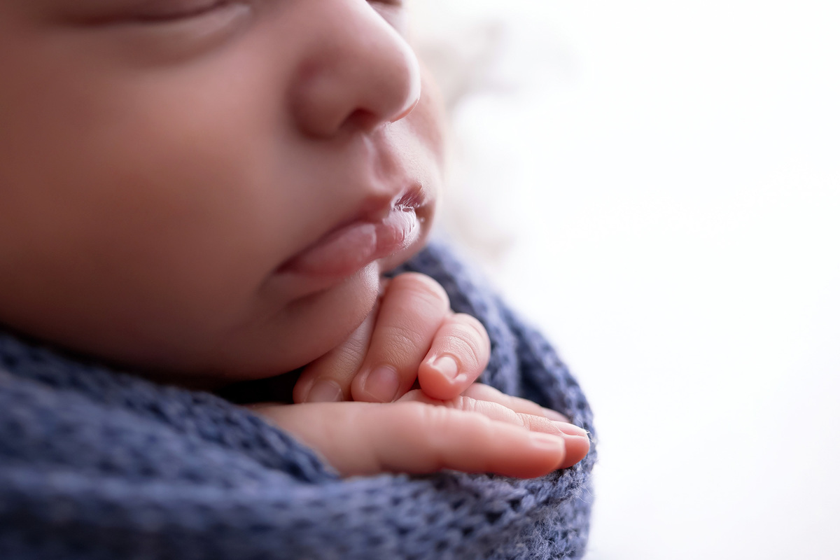 Bebê recém-nascido Levi enroladinho em tecido azul no baldinho durante ensaio newborn no estúdio On Click Fotografia em Caraguatatuba