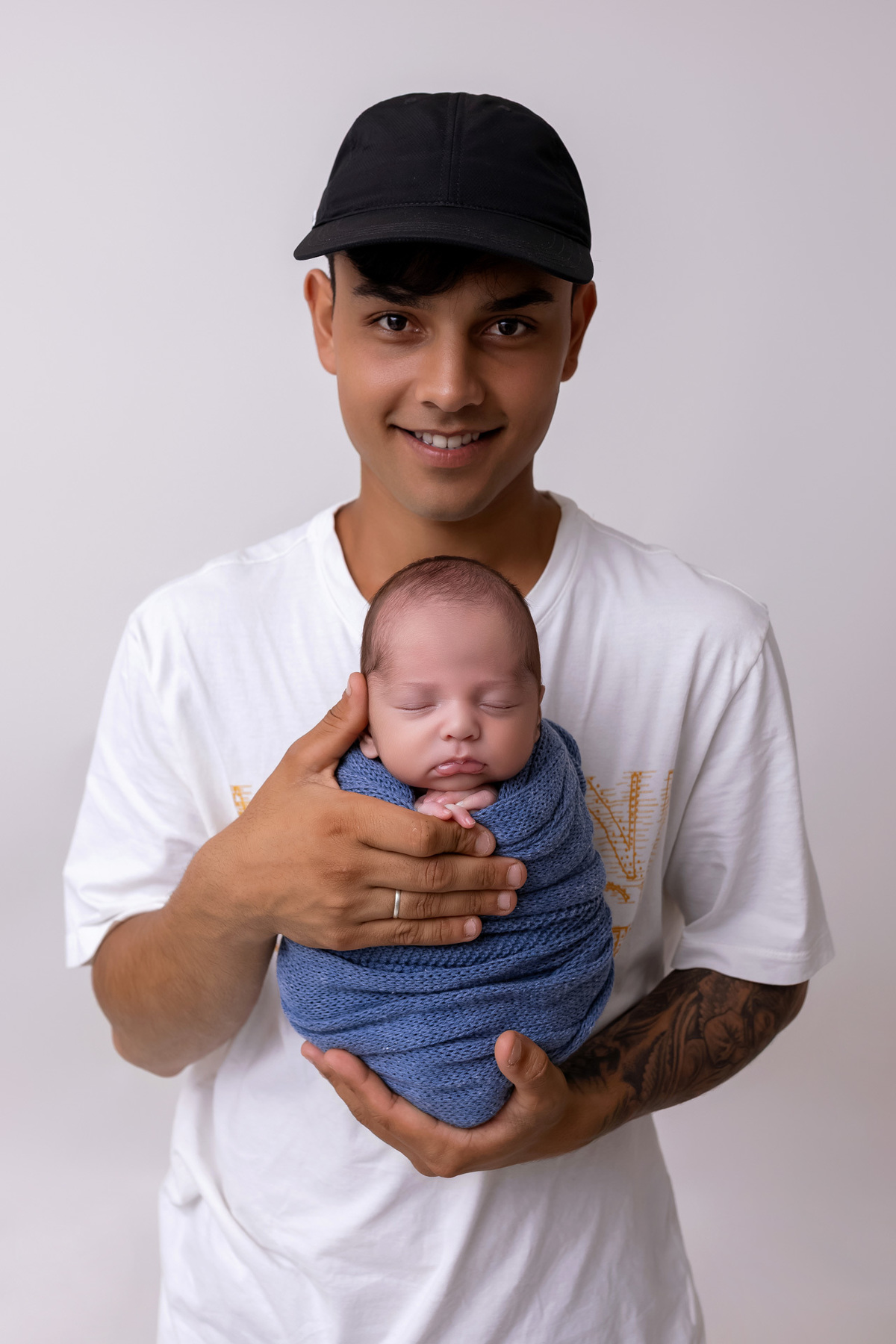 Bebê recém-nascido Levi enroladinho em tecido azul no baldinho durante ensaio newborn no estúdio On Click Fotografia em Caraguatatuba