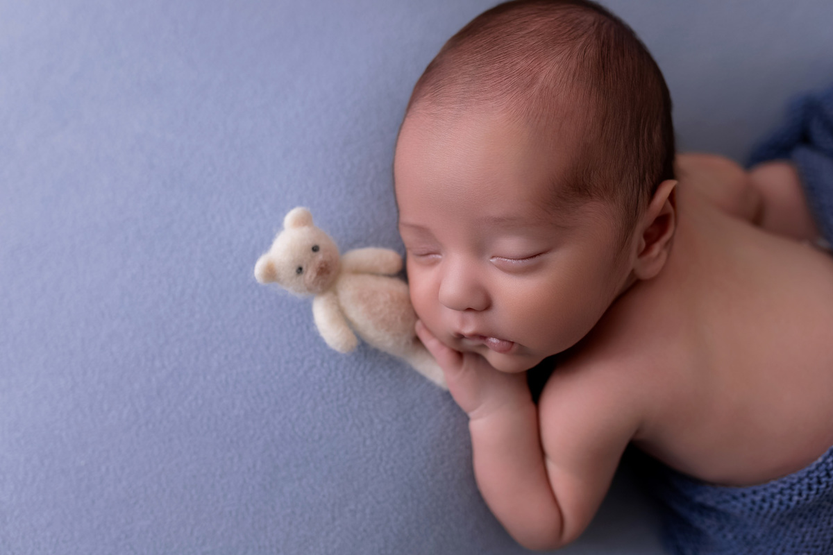 Bebê recém-nascido Levi enroladinho em tecido azul no baldinho durante ensaio newborn no estúdio On Click Fotografia em Caraguatatuba
