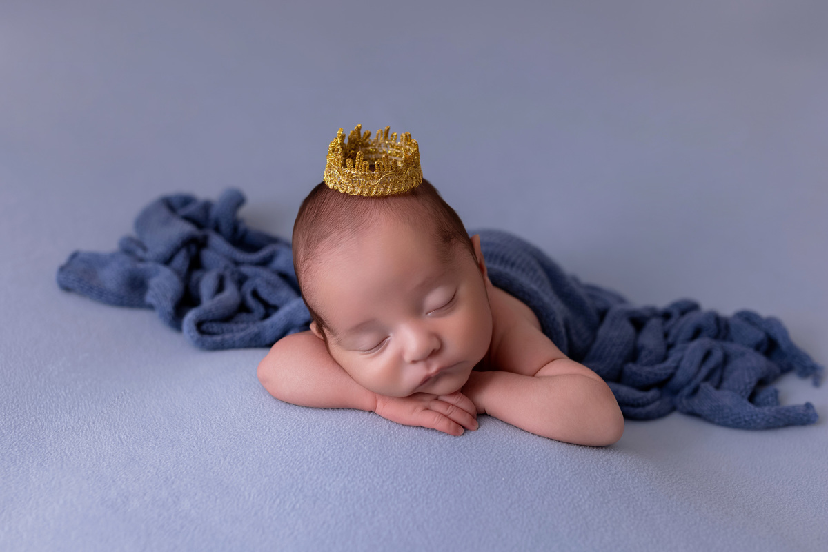 Bebê recém-nascido Levi enroladinho em tecido azul no baldinho durante ensaio newborn no estúdio On Click Fotografia em Caraguatatuba