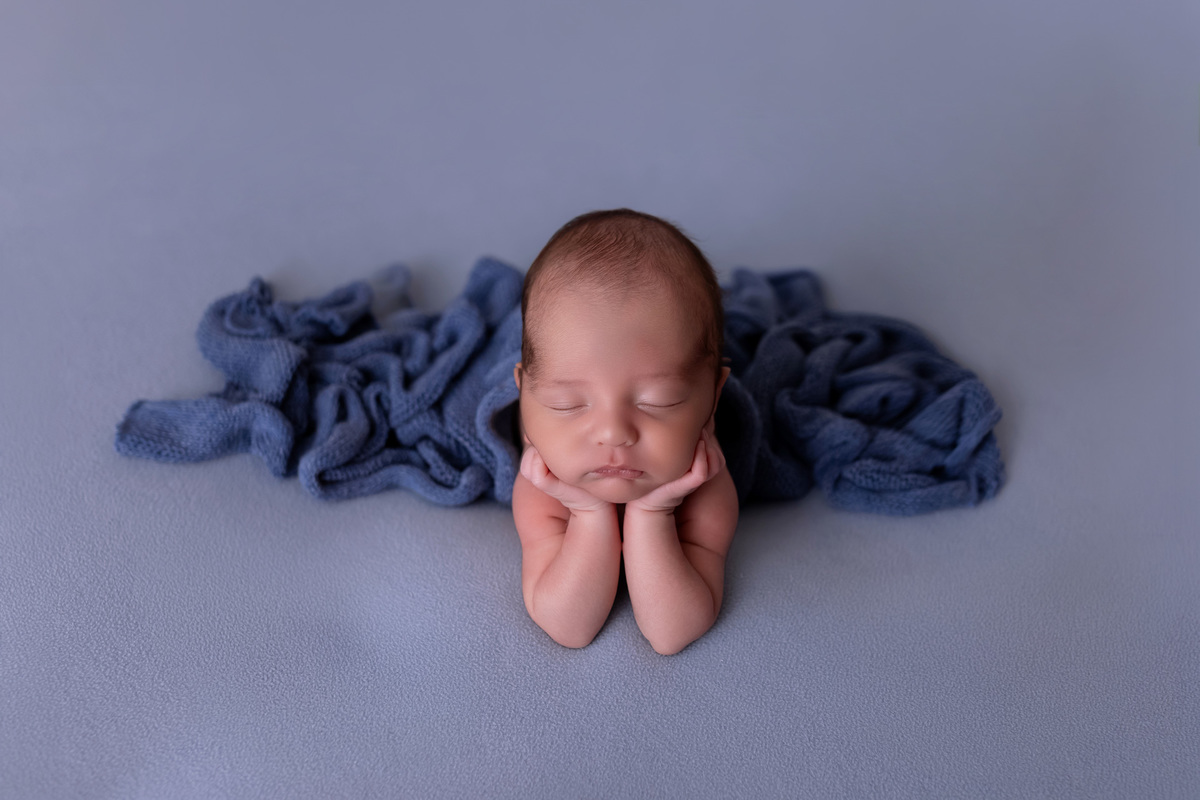 Bebê recém-nascido Levi enroladinho em tecido azul no baldinho durante ensaio newborn no estúdio On Click Fotografia em Caraguatatuba