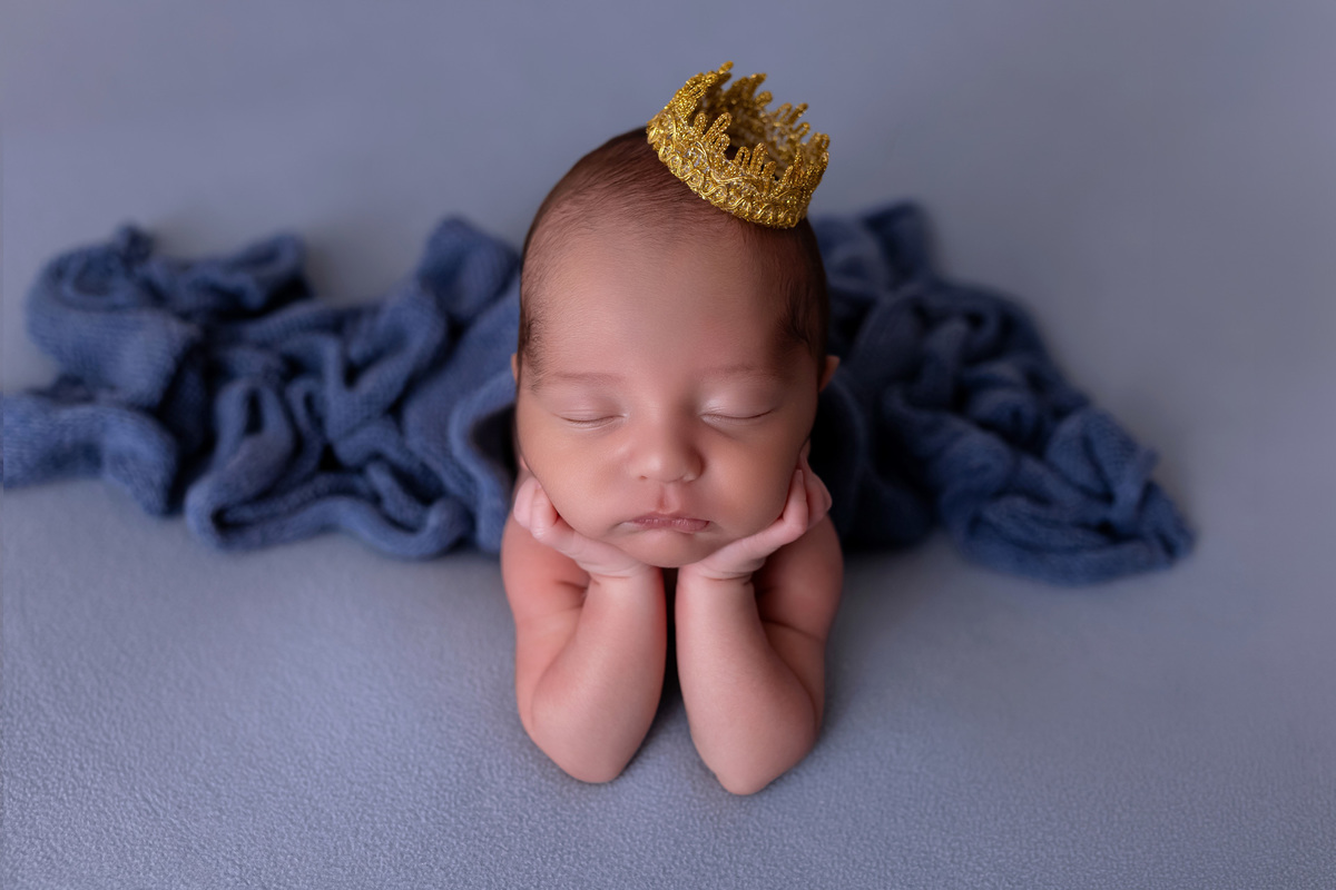 Bebê recém-nascido Levi enroladinho em tecido azul no baldinho durante ensaio newborn no estúdio On Click Fotografia em Caraguatatuba