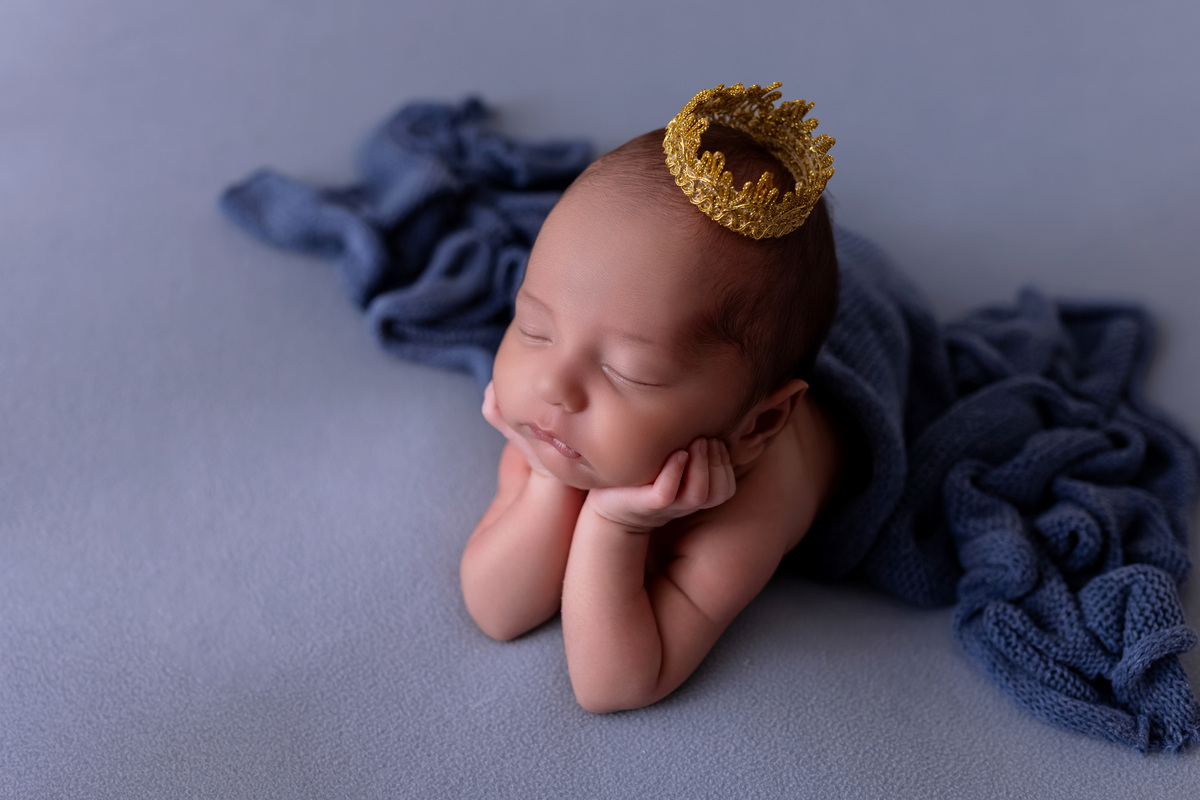 Bebê recém-nascido Levi enroladinho em tecido azul no baldinho durante ensaio newborn no estúdio On Click Fotografia em Caraguatatuba