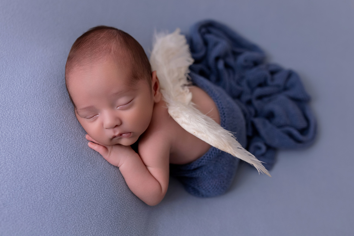 Bebê recém-nascido Levi enroladinho em tecido azul no baldinho durante ensaio newborn no estúdio On Click Fotografia em Caraguatatuba