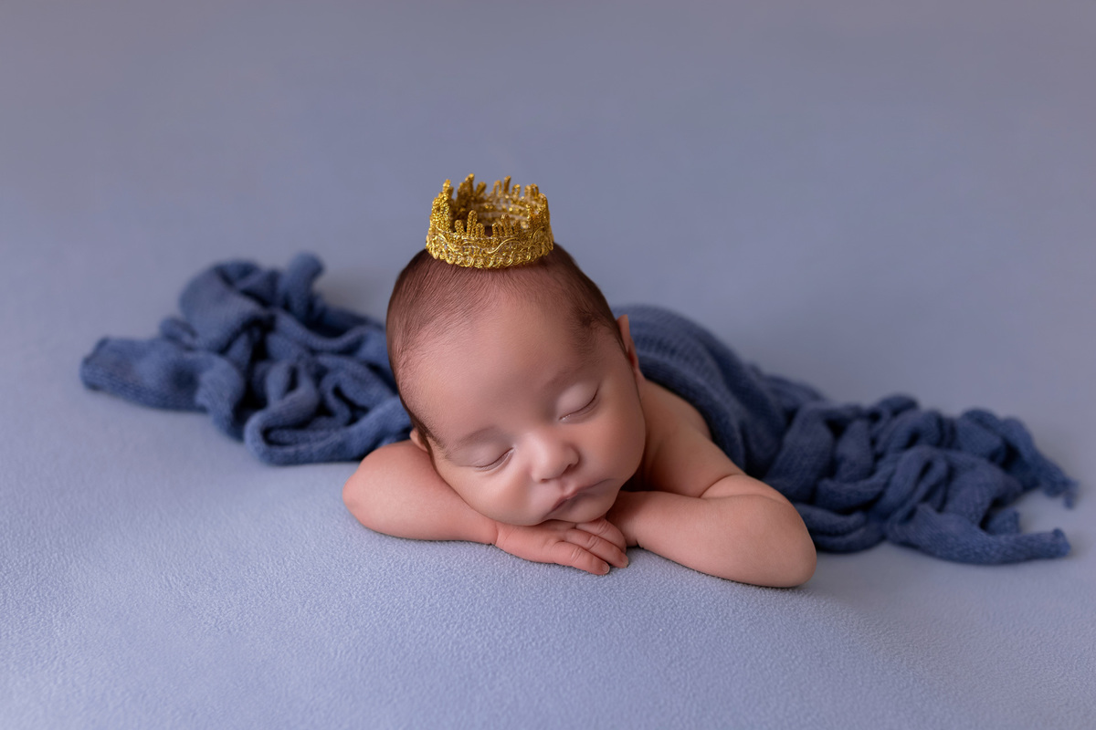 Bebê recém-nascido Levi enroladinho em tecido azul no baldinho durante ensaio newborn no estúdio On Click Fotografia em Caraguatatuba