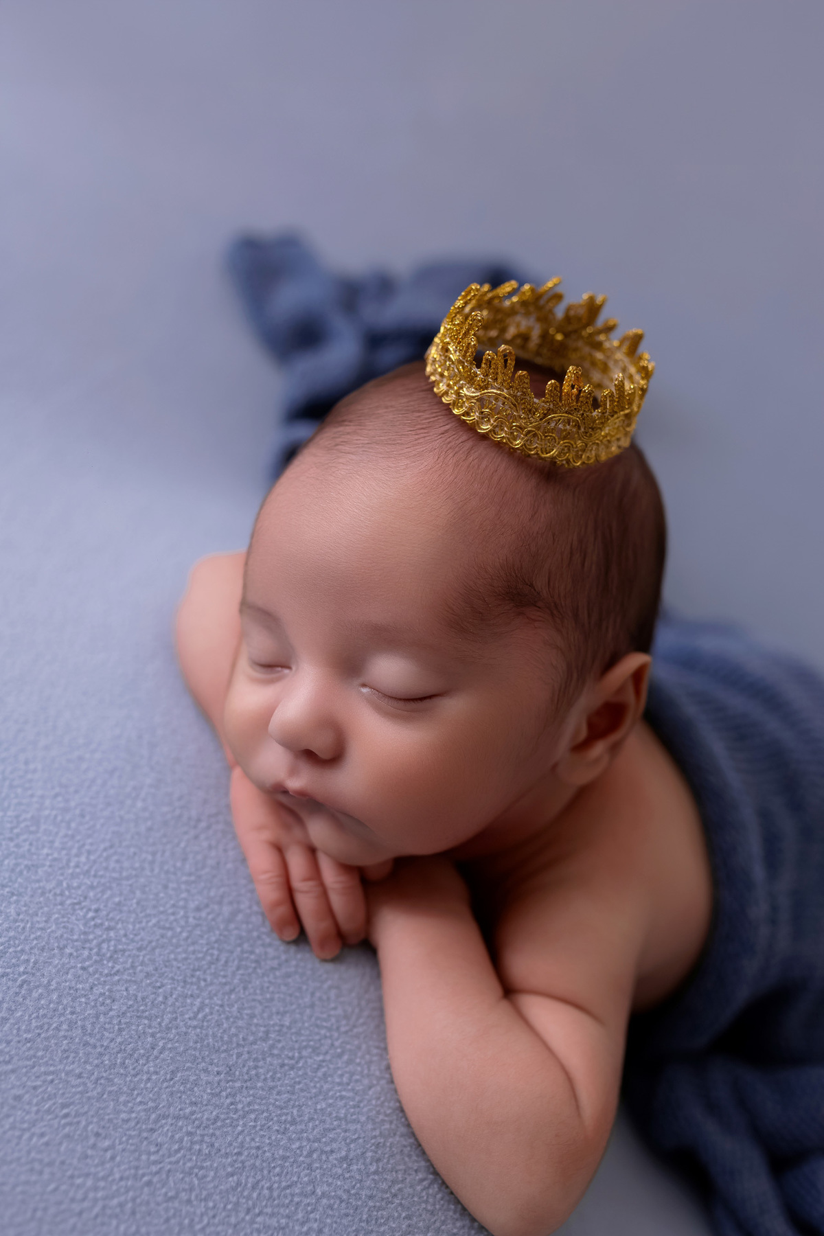 Bebê recém-nascido Levi enroladinho em tecido azul no baldinho durante ensaio newborn no estúdio On Click Fotografia em Caraguatatuba