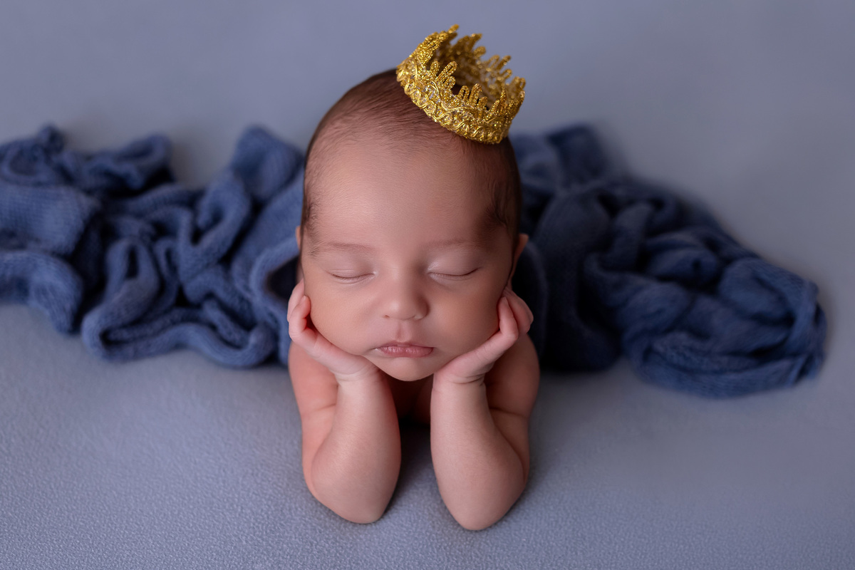 Bebê recém-nascido Levi enroladinho em tecido azul no baldinho durante ensaio newborn no estúdio On Click Fotografia em Caraguatatuba