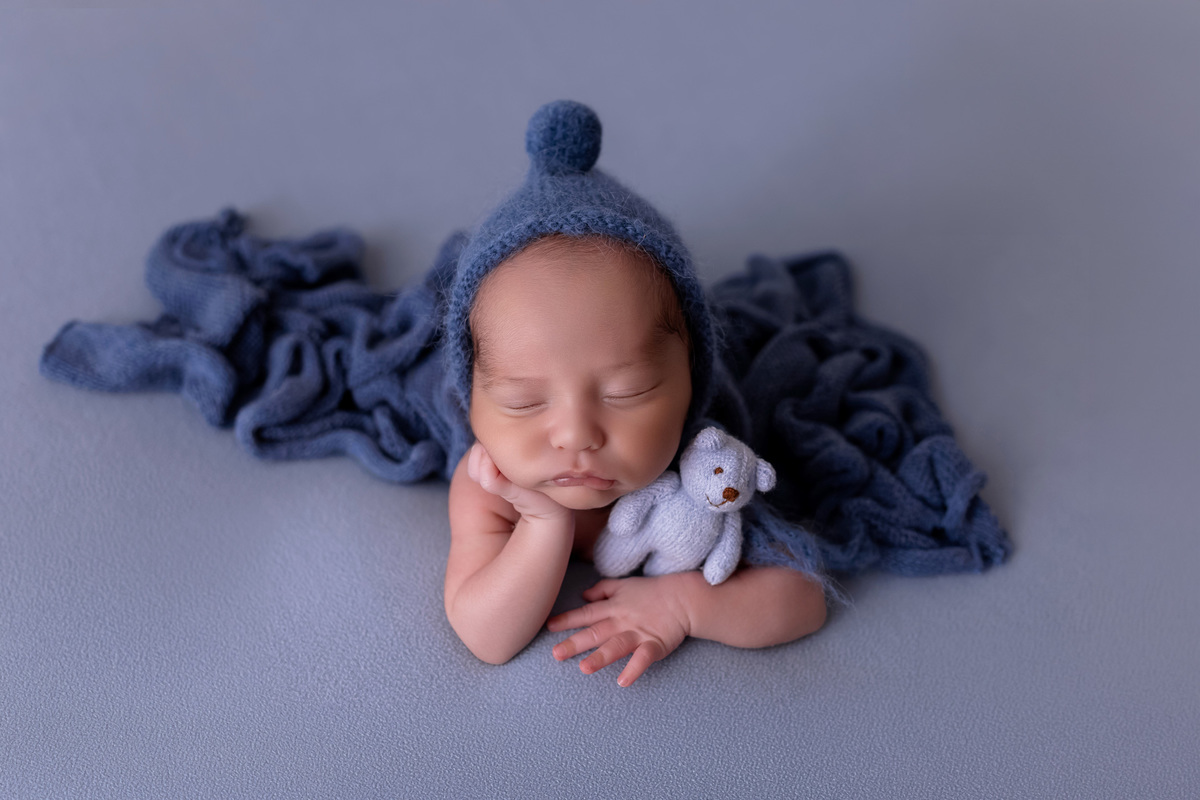 Bebê recém-nascido Levi enroladinho em tecido azul no baldinho durante ensaio newborn no estúdio On Click Fotografia em Caraguatatuba