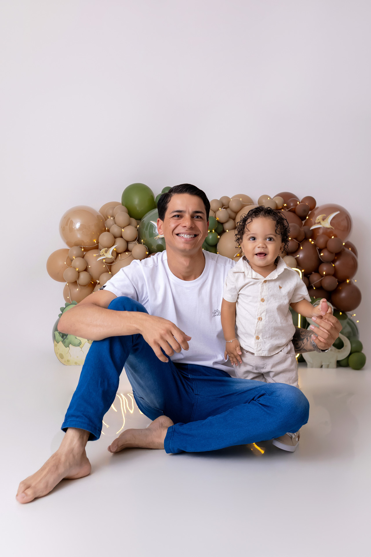 Bebê Arthur sorrindo no ensaio smash the cake tema baby dinossauro no estúdio On Click Fotografia em Caraguatatuba