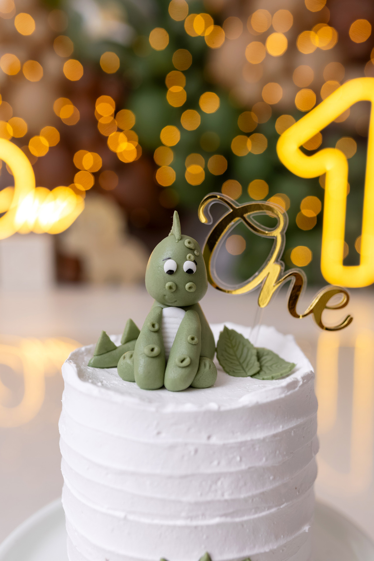 Bebê Arthur sorrindo no ensaio smash the cake tema baby dinossauro no estúdio On Click Fotografia em Caraguatatuba