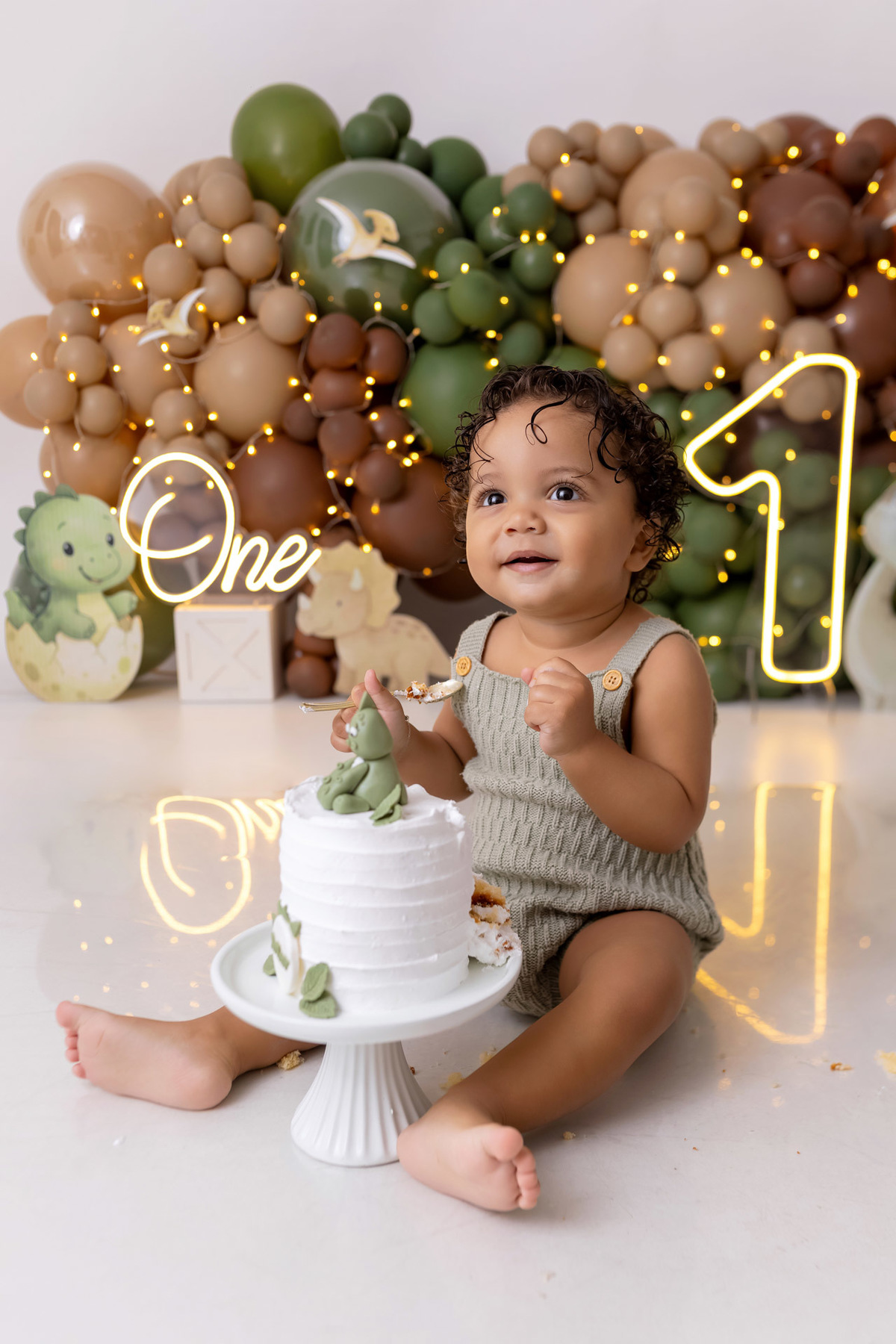 Bebê Arthur sorrindo no ensaio smash the cake tema baby dinossauro no estúdio On Click Fotografia em Caraguatatuba