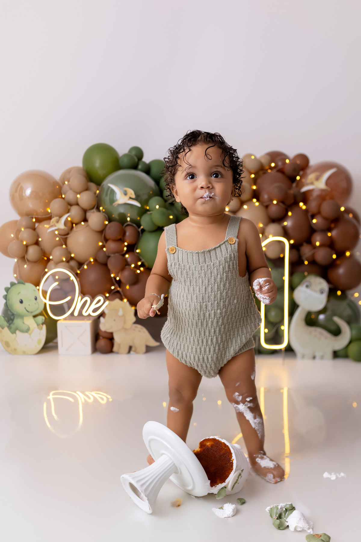 Bebê Arthur sorrindo no ensaio smash the cake tema baby dinossauro no estúdio On Click Fotografia em Caraguatatuba