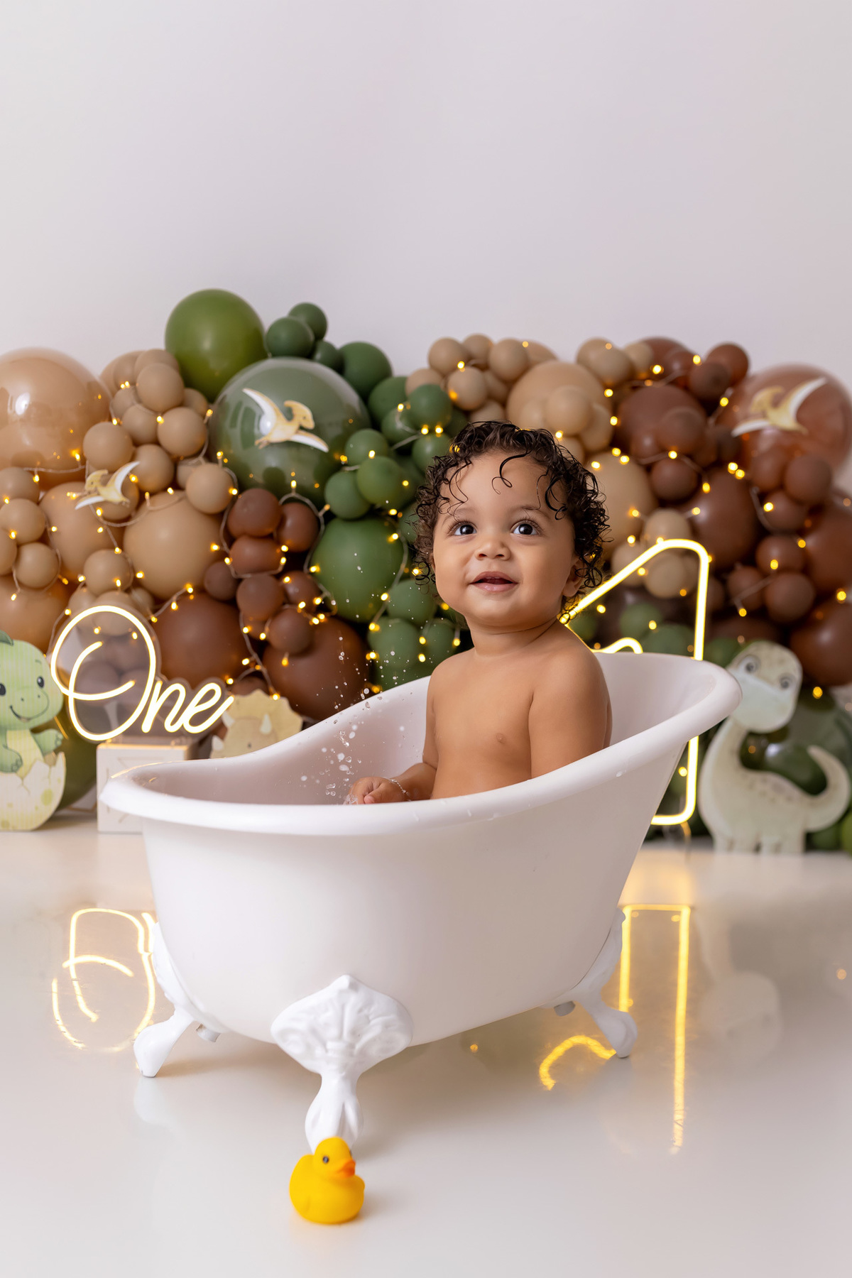 Bebê Arthur sorrindo no ensaio smash the cake tema baby dinossauro no estúdio On Click Fotografia em Caraguatatuba