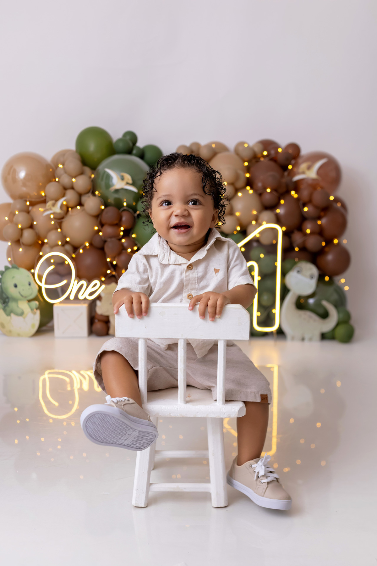 Bebê Arthur sorrindo no ensaio smash the cake tema baby dinossauro no estúdio On Click Fotografia em Caraguatatuba