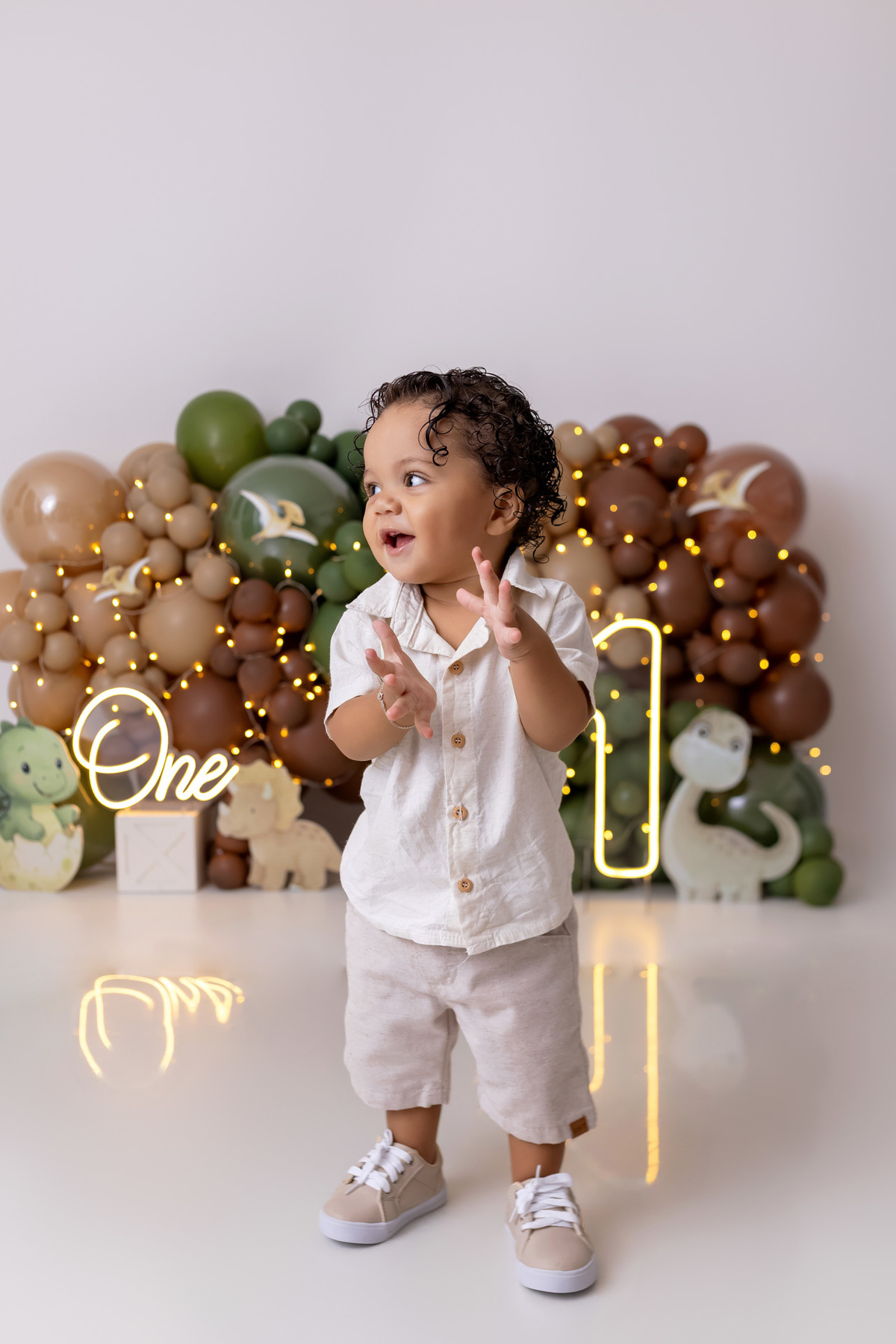 Bebê Arthur sorrindo no ensaio smash the cake tema baby dinossauro no estúdio On Click Fotografia em Caraguatatuba