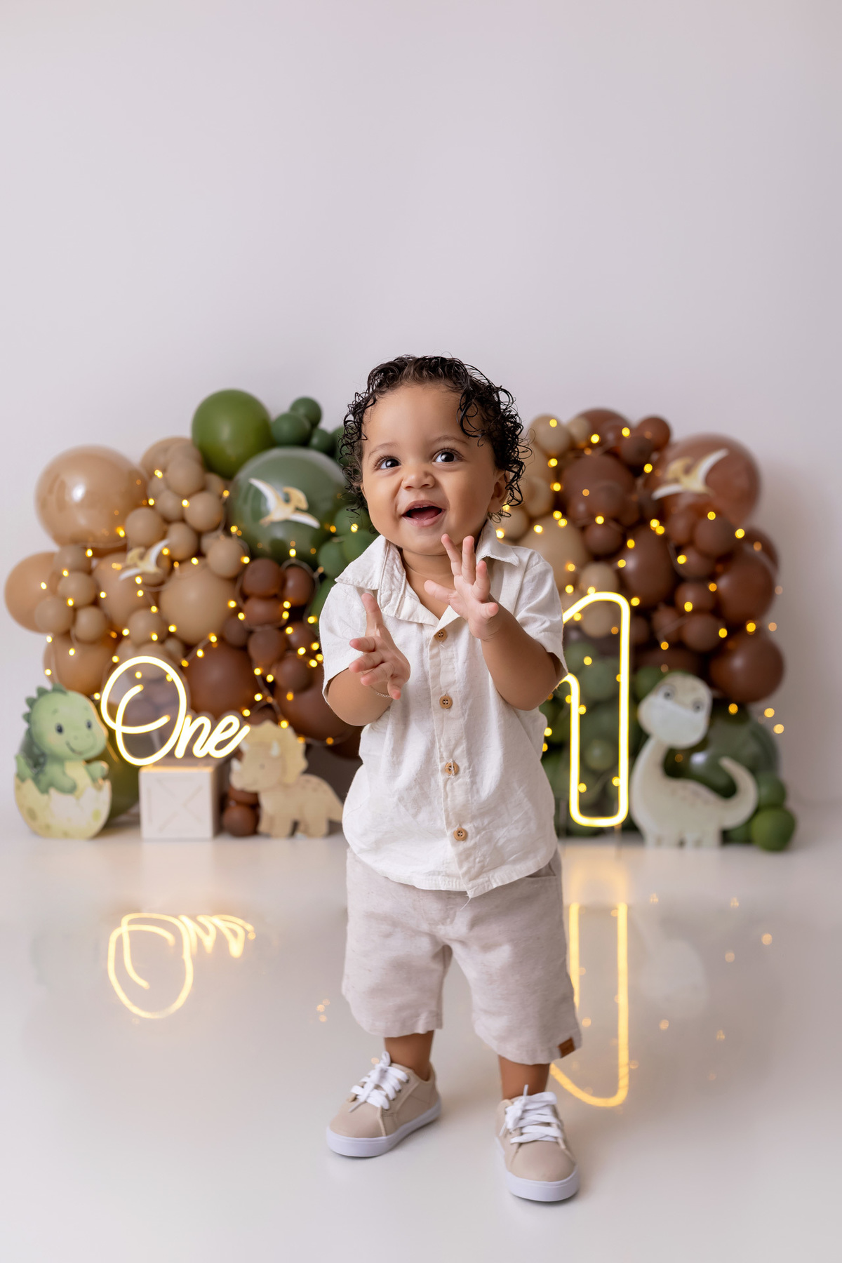 Bebê Arthur sorrindo no ensaio smash the cake tema baby dinossauro no estúdio On Click Fotografia em Caraguatatuba
