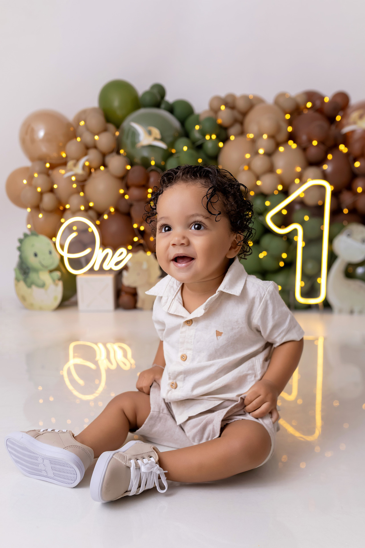 Bebê Arthur sorrindo no ensaio smash the cake tema baby dinossauro no estúdio On Click Fotografia em Caraguatatuba