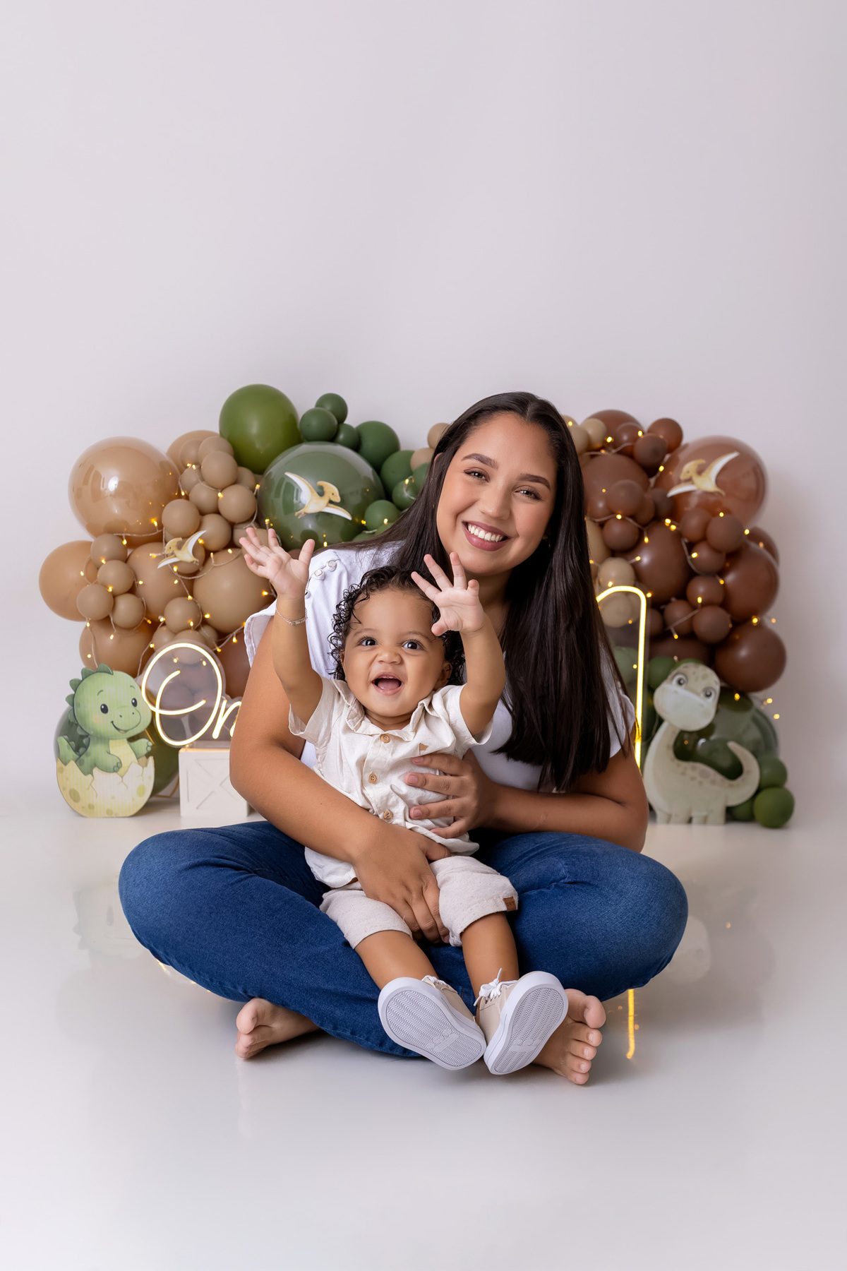 Bebê Arthur sorrindo no ensaio smash the cake tema baby dinossauro no estúdio On Click Fotografia em Caraguatatuba