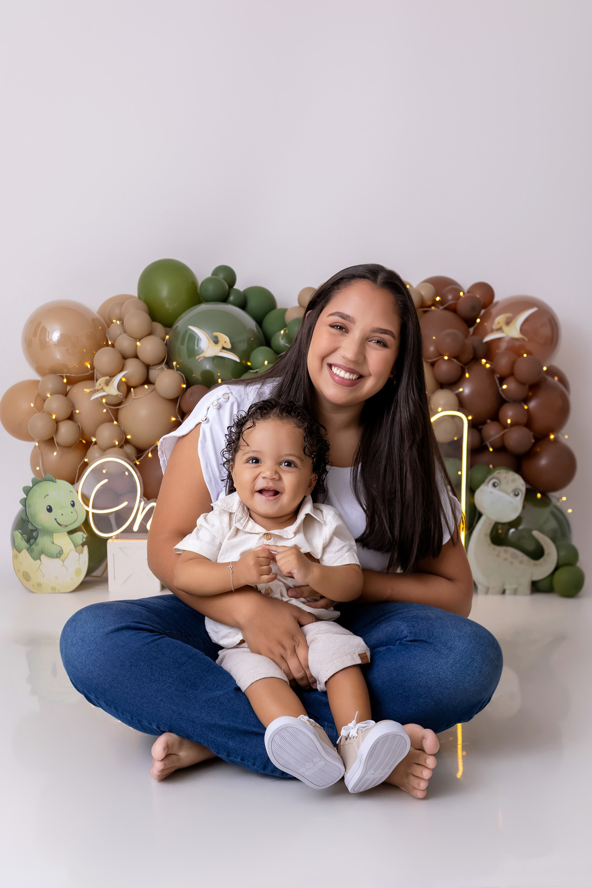 Bebê Arthur sorrindo no ensaio smash the cake tema baby dinossauro no estúdio On Click Fotografia em Caraguatatuba