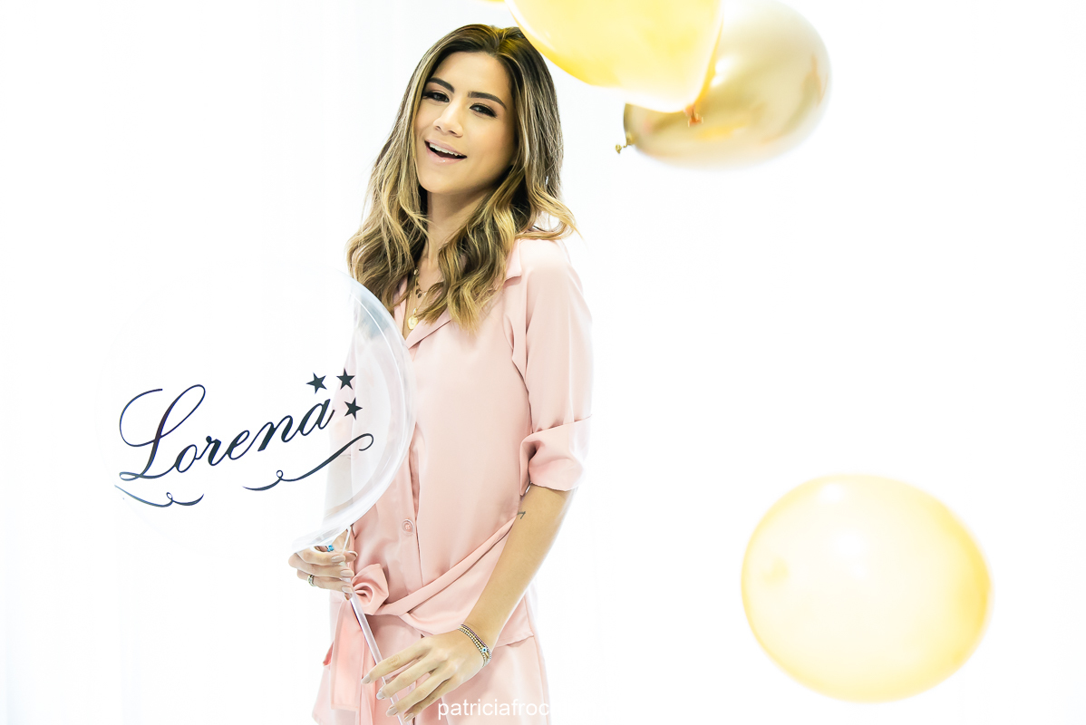 Modelo com roupa rosa posa com balão com o próprio nome Lorena em Ensaio fotografico de aniversario com luz natural em estudio na Gloria Zona Sul do Rio de Janeiro 