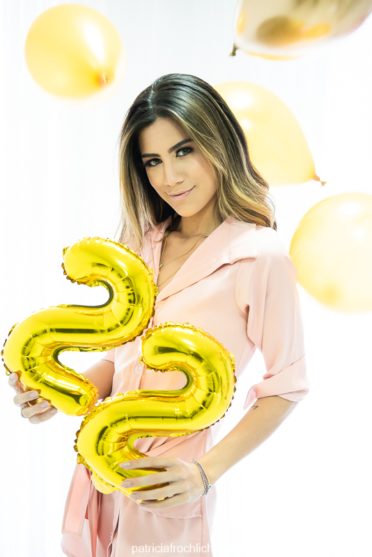 Modelo com roupa rosa posa com balões bexigas de vinte e dois 22 em Ensaio fotografico de aniversario com luz natural em estudio na Gloria Zona Sul do Rio de Janeiro 