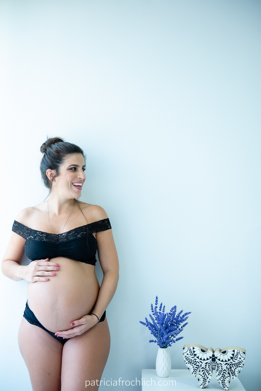 gravida com lingerie preta na parede branca. ensaio gestante estúdio rio de janeiro. ensaio com luz natural. ensaio feminino.
