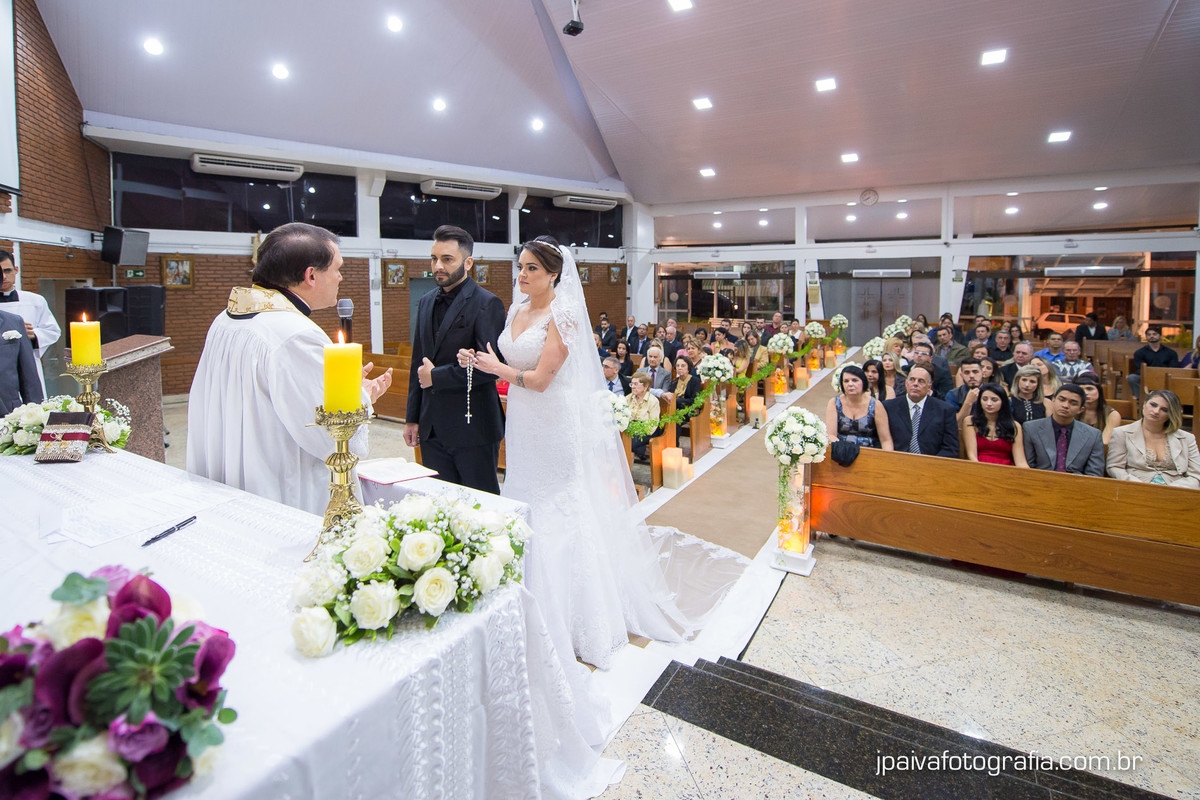 noivos se olhando no altar durante o casamento Mariana e Rogerio na  igreja Paróquia Sagrada Família Diocese de Santo Amaro