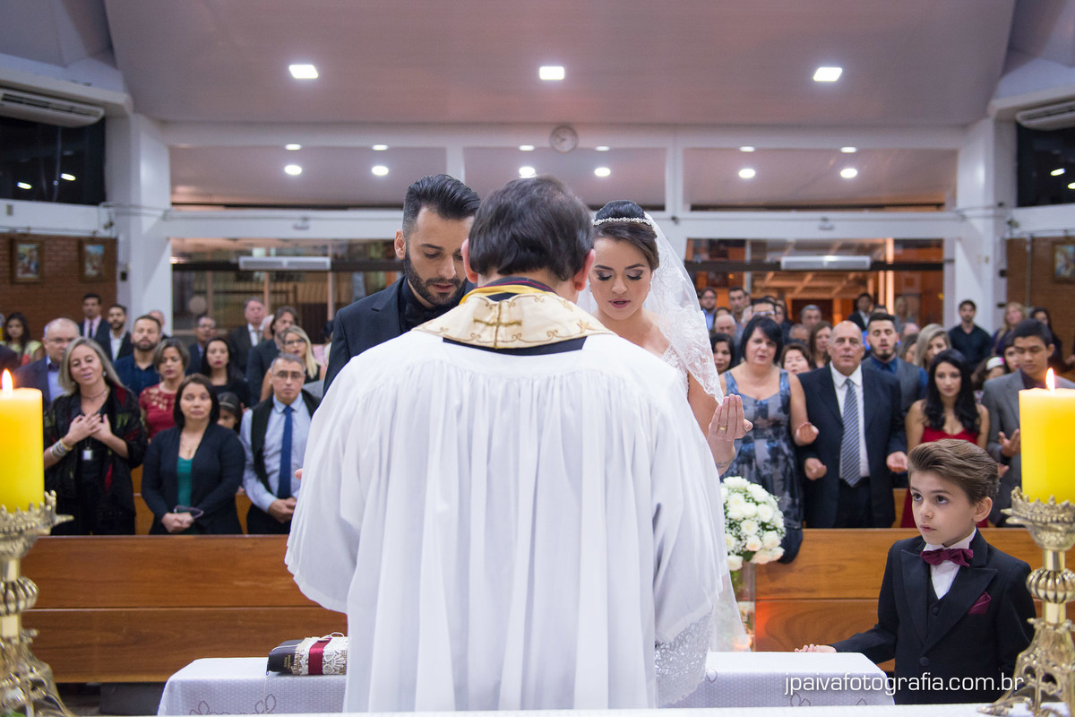 noivos orando mão da noiva após a troca de alianças no altar durante o casamento Mariana e Rogerio na  igreja Paróquia Sagrada Família Diocese de Santo Amaro