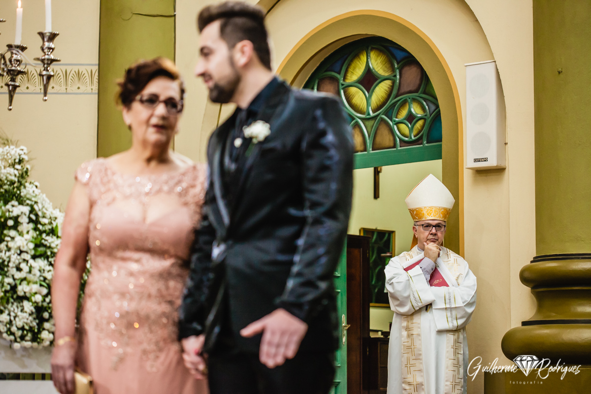 Mãe do noivo e noivo no altar junto com o bispo de Azambuja.