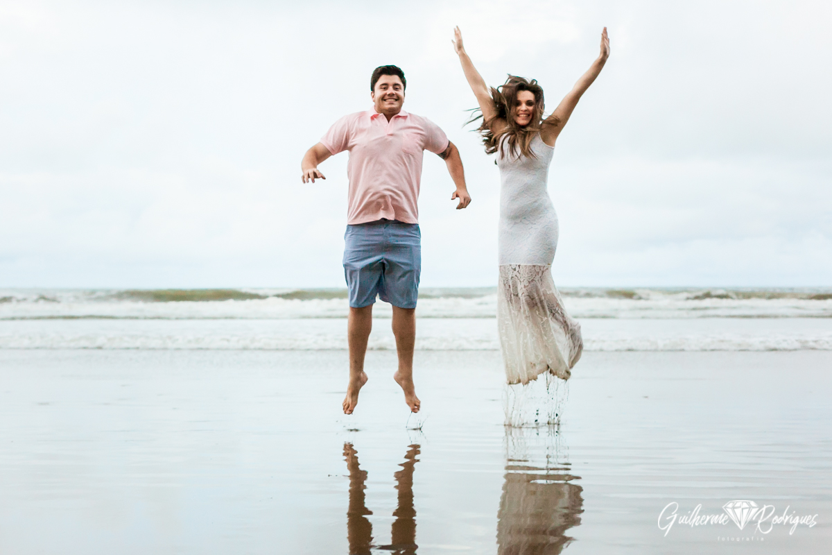 Noivos pulando na praia durante a sessão de fotos do pré casamento. Fotógrafo de casamento de Itajaí Guilherme Rodrigues.