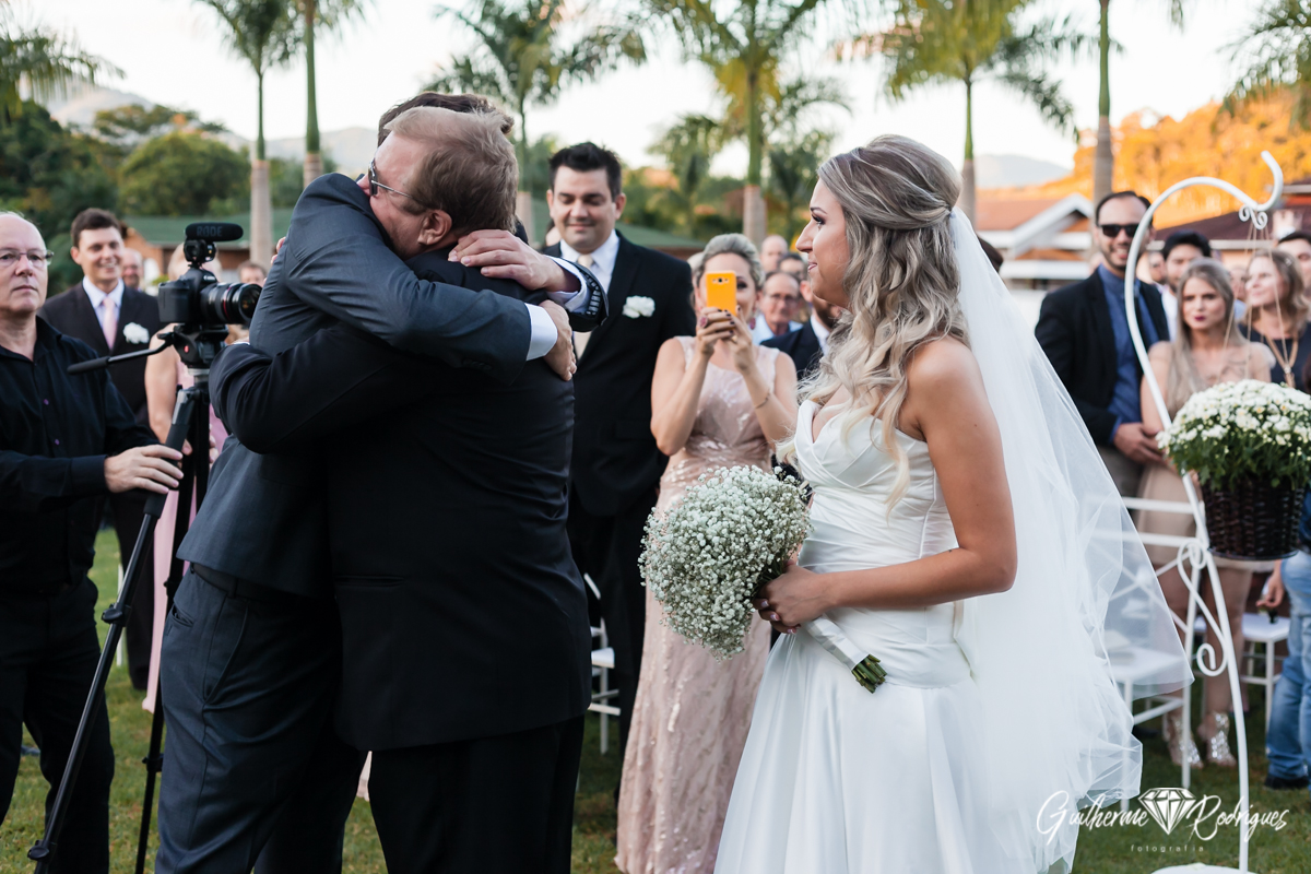 A chegada da noiva ao altar. Noivo abraçando o sogro.
