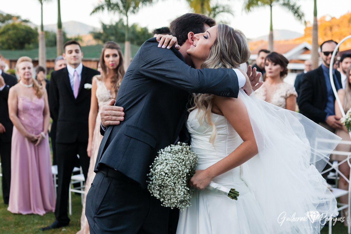 Abraço da noiva e do noivo. Casamento de dia ao ar livre. Fotógrafo Guilherme Rodrigues.