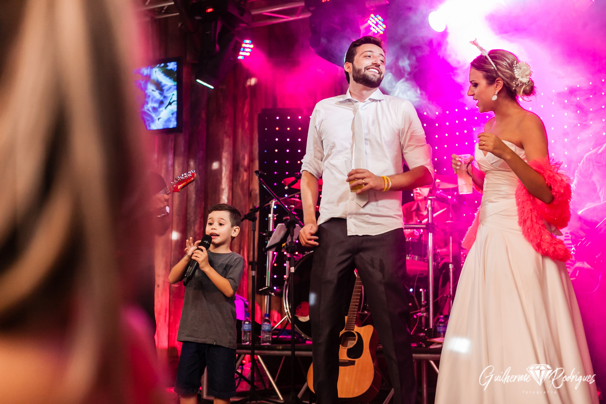 Noivos no palco com o sobrinho cantor. Fotógrafo de casamento em Brusque Guilherme Rodrigues.