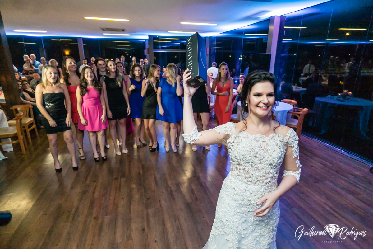 Noiva jogando o buquê para as solteiras. Local da festa, casa suiça.