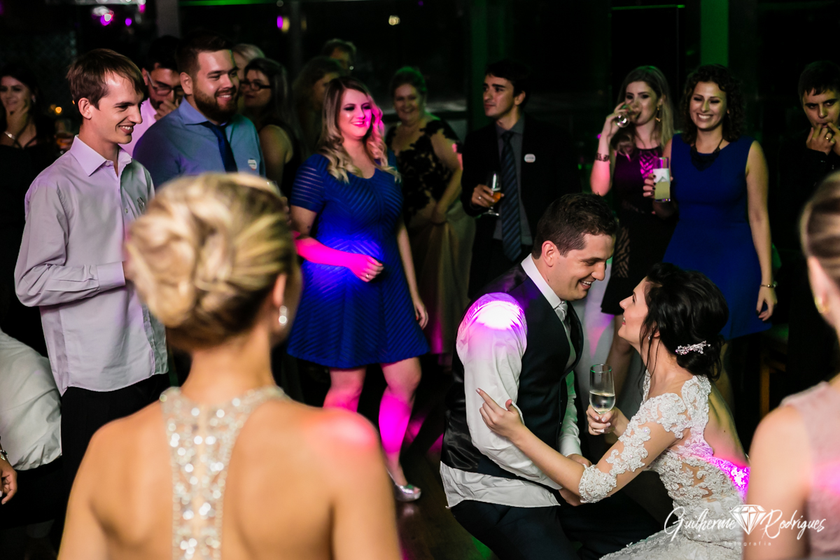 Noivos dançando com os amigos na festa de casamento.
