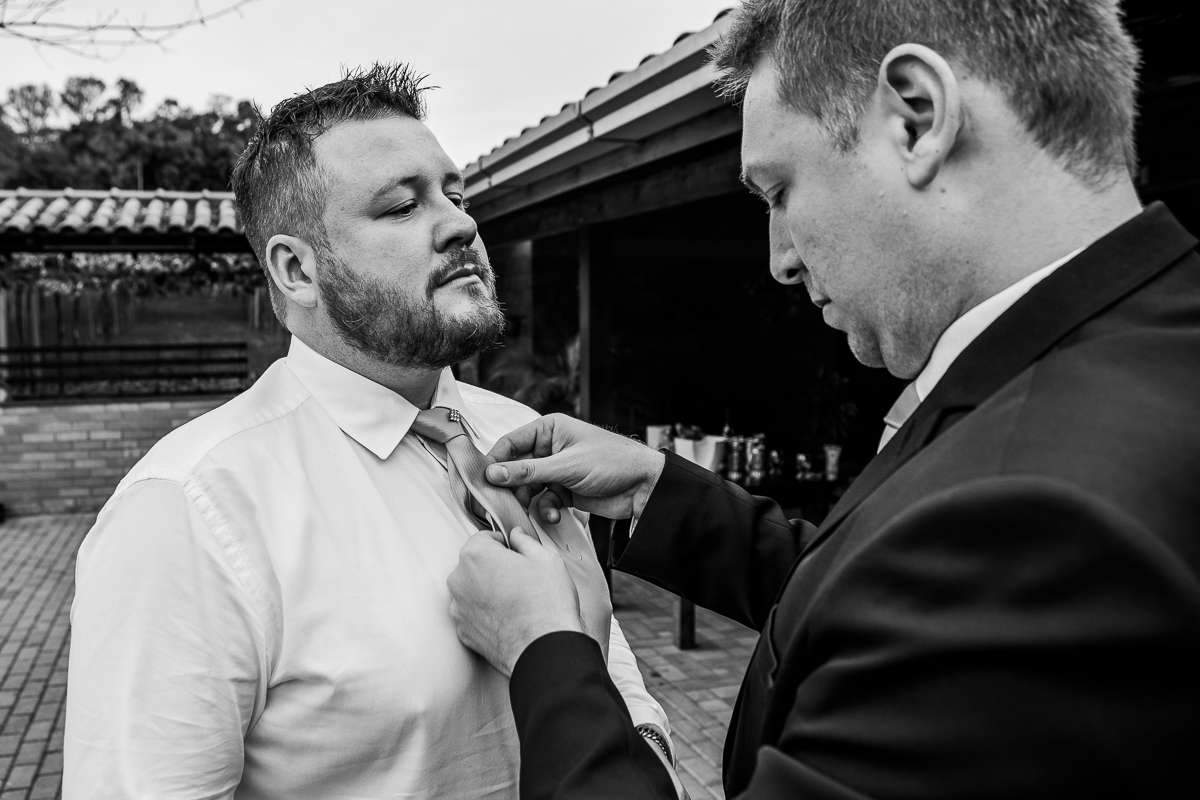 Padrinho dando aquele toque especial na gravata do noivo
