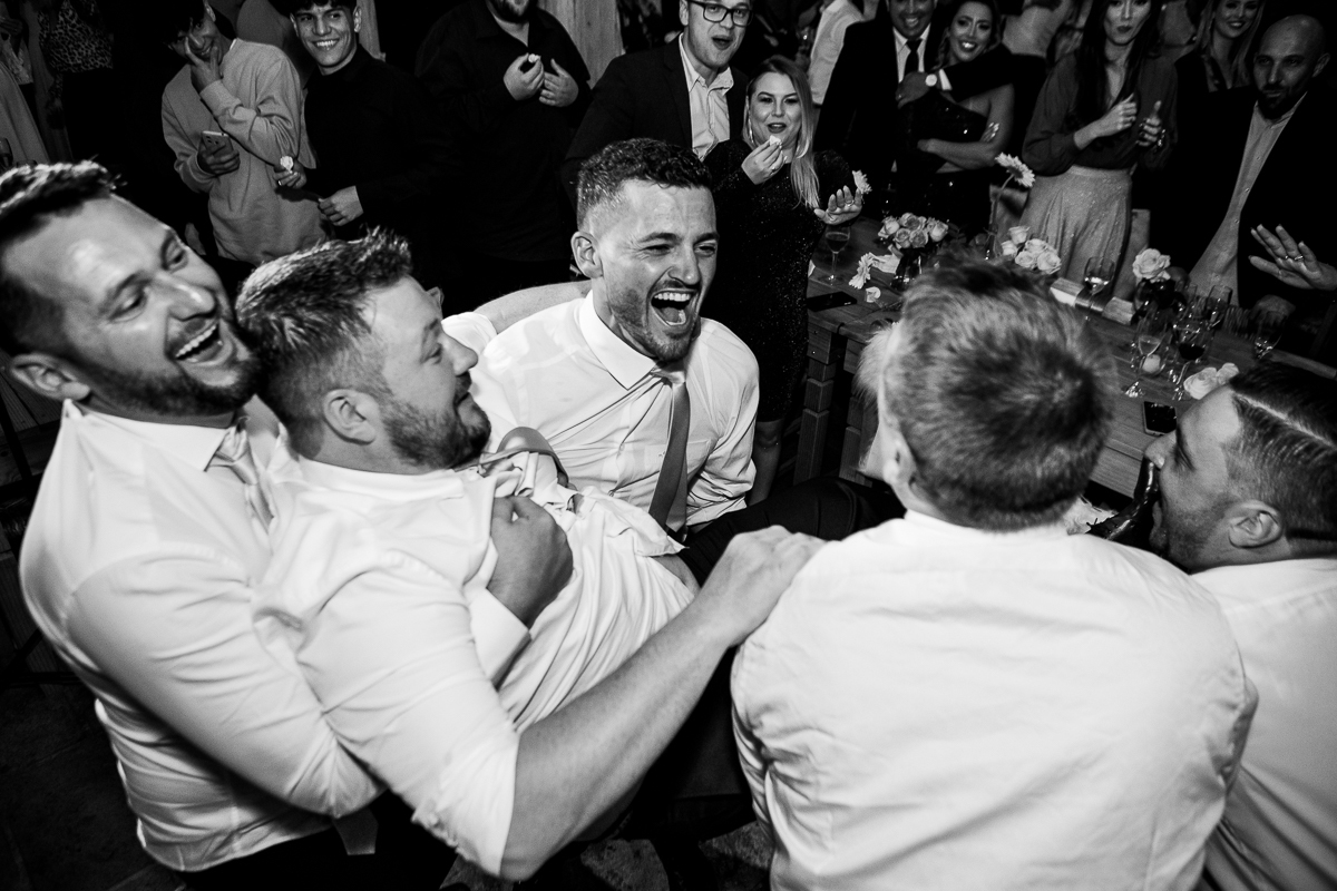 O noivo e seus padrinhos se divertem enquanto se preparam para o casamento.