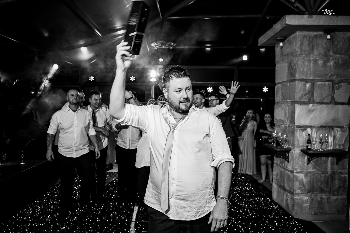 Noivo arremeçando o presente para os padrinhos