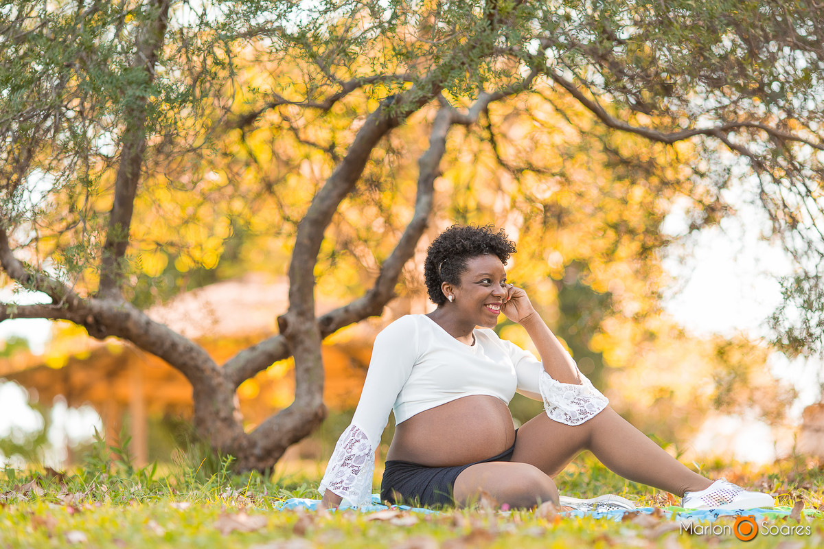 mamãe grávida sentada no gramado